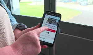Une personne consulte sur son téléphone un modèle pétition locataires sur Change.org, demandant des logements dignes.