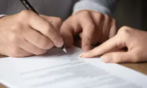 Signature sur un document, peut-être une lettre recommandée pour un préavis.