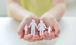 Mains tenant une famille en papier, symbole d'espoir pour une lettre demande agrément adoption.