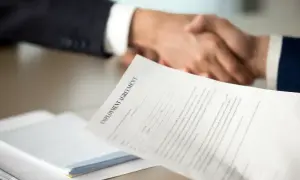 Poignée de main après la signature d'un contrat. Une lettre de motivation pour un poste d'assistant manager est visible.