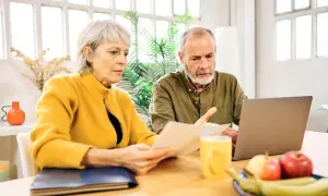 Couple âgé examinant un relevé de carrière, peut-être pour une lettre de demande de régularisation.