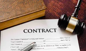 Un contrat, un livre ancien et un maillet de juge. Un exemple de lettre de fin de mission pour un contrat.