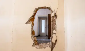 Trou dans un mur révélant une porte. Idéal pour un modèle lettre logement insalubre.