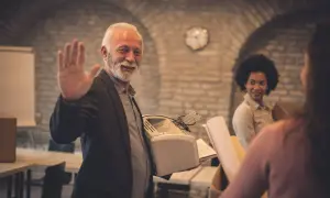 Un homme agite la main, tenant une imprimante. Il pourrait chercher un modèle de lettre de démission aide à domicile.