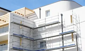 Immeuble blanc en construction avec échafaudages. Idéal pour un modèle lettre bailleur sociaux pour travaux.