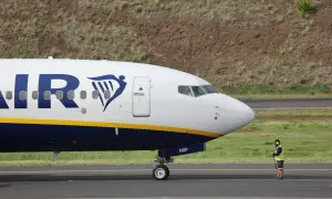 Un avion Ryanair sur le tarmac, prêt pour sa prochaine **reclamation**. Un agent au sol veille.