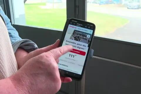Une personne consulte sur son téléphone un modèle pétition locataires sur Change.org, demandant des logements dignes.