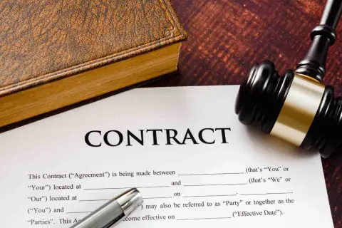 Un contrat, un livre ancien et un maillet de juge. Un exemple de lettre de fin de mission pour un contrat.
