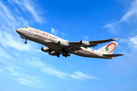 Un avion de la RAM, un Boeing 747-400, décolle sous un ciel bleu et nuageux.