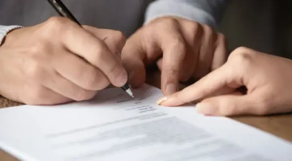 Signature sur un document, peut-être une lettre recommandée pour un préavis.