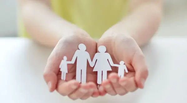 Mains tenant une famille en papier, symbole d'espoir pour une lettre demande agrément adoption.