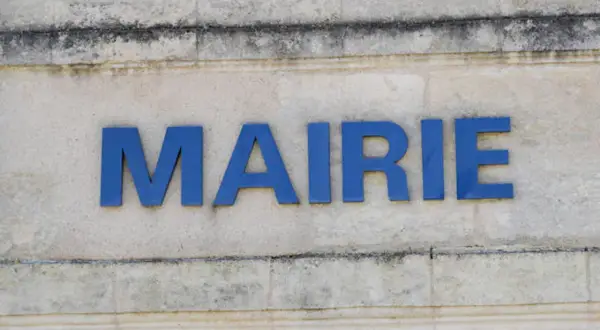 Les lettres bleues "MAIRIE" sur un mur en pierre. Idéal pour illustrer une lettre de motivation fonction publique.