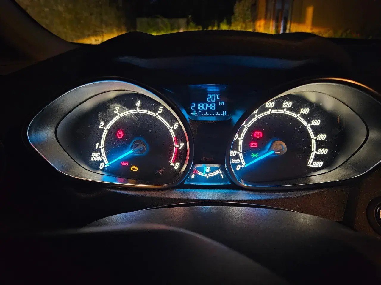 Tableau de bord d'une Ford, allumé la nuit. Le kilométrage est de 218048 km. Cela pourrait servir de preuve pour une lettre de réclamation Ford France.