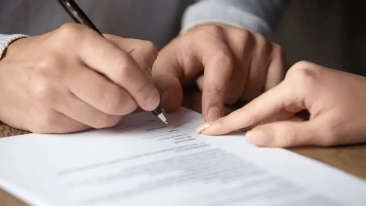 Signature sur un document, peut-être une lettre recommandée pour un préavis.