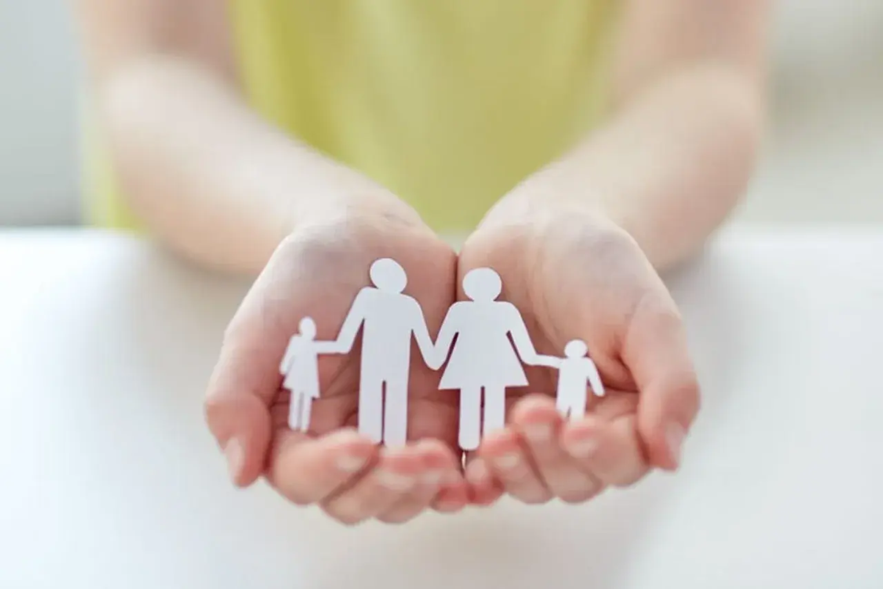 Mains tenant une famille en papier, symbole d'espoir pour une lettre demande agrément adoption.