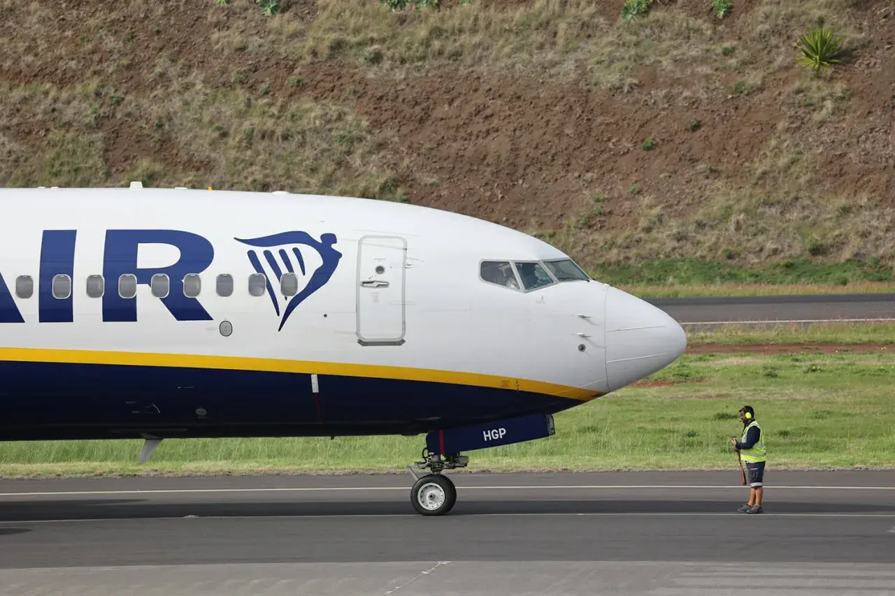 Un avion Ryanair sur le tarmac, prêt pour sa prochaine **reclamation**. Un agent au sol veille.