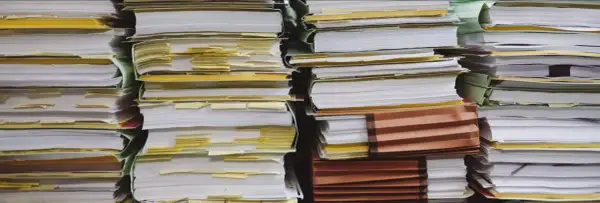 Piles of documents, some with yellow tabs, suggest a complex administrative process, perhaps a demande de relevé de carrière par courrier.